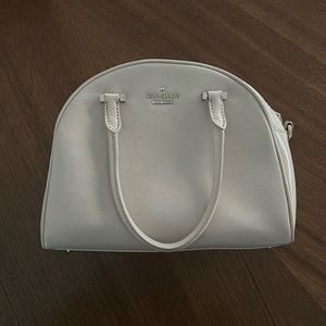 Kate Spade bone colored purse with adjustable shoulder strap and handles.